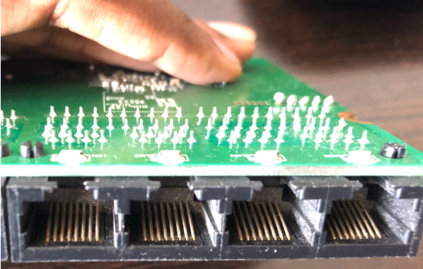 Close-up of RJ45 ethernet ports on a PCB showing all eight metallic contacts of a gigabit-capable router